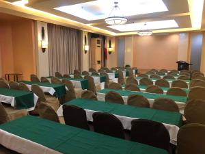 una sala de conferencias con mesas y sillas verdes y blancas en Hotel Lorenza en Tacloban