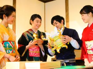 un grupo de mujeres de pie alrededor de un hombre sosteniendo un trofeo en Yutorelo Yamaga en Yamaga