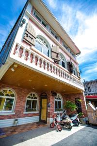 a building with two motorcycles parked in front of it at Fish Villa 38 in Xiaoliuqiu