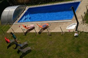 a group of people sitting in chairs next to a swimming pool at Hotel Avalanche in Štôla