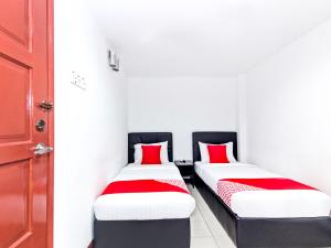 two beds in a room with red pillows at Super OYO 321 Hotel D'Elegant in Kuala Lumpur