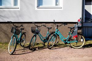 Hay cuatro bicicletas estacionadas al lado de un edificio. en Klintvägen Apartments, en Mariehamn