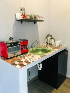 cocina con microondas rojo y fregadero en CASA MALIX Puerto Morelos en Puerto Morelos