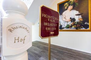 una botella de vino y un cartel junto a un cuadro en Hotel Rheinischer Hof Bad Soden, en Bad Soden am Taunus