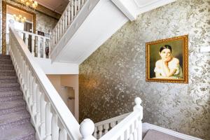 un escalier dans une maison ornée d'une peinture murale dans l'établissement Hotel Rheinischer Hof Bad Soden, à Bad Soden am Taunus