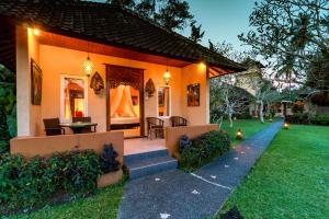 una casa con patio arredato con tavolo e sedie di Tanah Merah Art Resort by AGATA ad Ubud Altre 37 foto