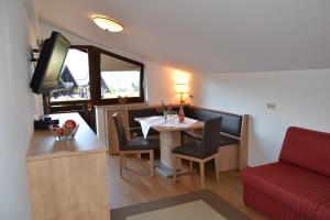 a small dining room with a table and a red couch at Gästehaus Elisabeth in Radstadt