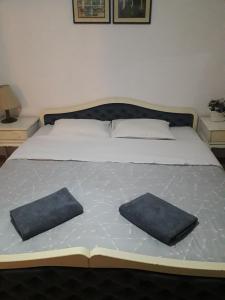 a bed with two pillows on top of it at Bochkar Guest House in Ohrid