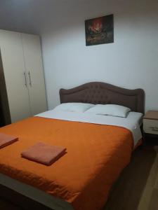a bedroom with a large bed with an orange blanket at Bochkar Guest House in Ohrid
