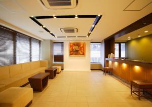 a waiting room with couches and tables in a building at Hotel Sorriso Hamamatsu in Hamamatsu