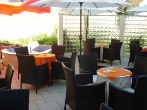 a restaurant with tables and chairs and an umbrella at Hotel Mladimir in Daruvar