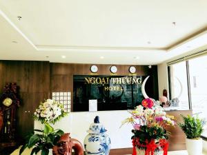 a room with vases of flowers and a sign at Ngoại Thương Hotel Từ Sơn Bắc Ninh in Bình Ha