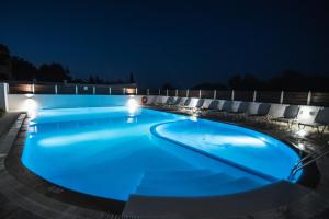 una piscina iluminada por la noche en Alex Apartment Suites, en Virós