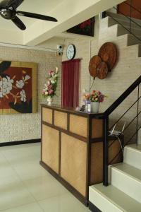 una habitación con una escalera y un reloj en la pared en Spa Guest House, en Jomtien Beach