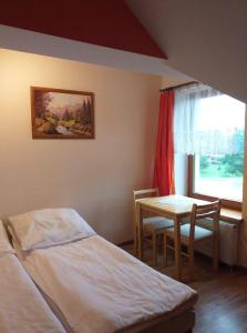 a room with two beds and a table and a window at Zajazd Joniec Małgorzata in Dobra
