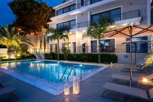 a swimming pool in front of a building at night at Melina Apartments Sea View in Argostoli