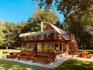 una cabaña de madera con mesas de picnic en un parque en Nurga Holiday Homes en Käina