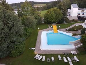 an overhead view of a swimming pool with chairs and trees at Ferienwohnung Bergpanorama mit Pool in Sankt Englmar