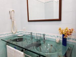 ein Badezimmer mit einem Glaswaschbecken und einem Telefon in der Unterkunft Villa Kalimera in Sorrent