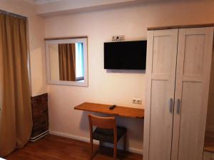 a room with a desk and a television on the wall at LV Rooms & Apartments am Lützowplatz in Berlin