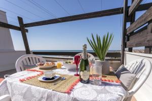 a table with a bottle of wine on a balcony at Luxury Penthouse in Naturiste; FKK, Nudist Village in Cap d'Agde