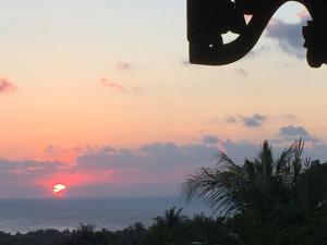 a sunset over the ocean with the sun in the sky at Cocohuts Hotel in Karimunjawa