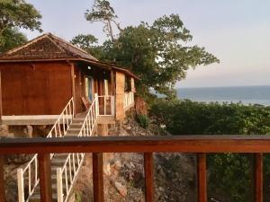 a house on a hill with a balcony at Cocohuts Hotel in Karimunjawa