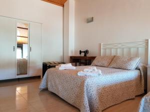 a bedroom with a bed with towels on it at Casa vacacional El Arroyo in Ferreras de Arriba +97 photos