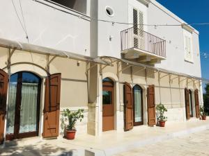 a building with wooden doors and a balcony at Tenuta Vigna del Noce in Corato