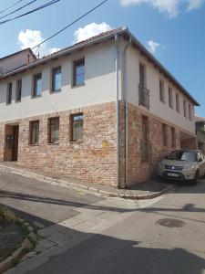 un bâtiment en briques avec une voiture garée devant lui dans l'établissement Központhoz közeli - Cool Tettye Apartman, à Pécs
