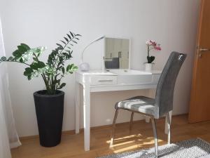 - un bureau blanc avec un miroir et une chaise dans l'établissement Központhoz közeli - Cool Tettye Apartman, à Pécs