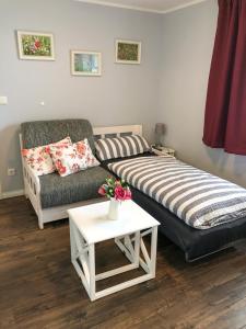 a living room with a bed and a couch and a table at Reetferienhaus - Schaprode Hafen in Schaprode