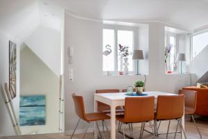 a dining room with a white table and chairs at Barfot Apartments in Bergen