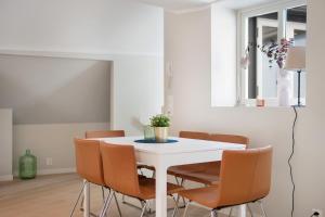 Barfot Apartments في بيرغِن: غرفة طعام بيضاء مع طاولة بيضاء وكراسي