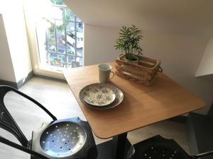 una mesa con un tazón y un jarrón. en OFFRE SPECIALE Centre Verdun - Idéal Visites - Le Puisatier en Verdún