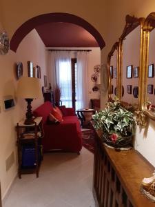 - un salon avec un canapé rouge et un miroir dans l'établissement Casa Boutique Angelika, à Porto Pozzo