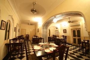 a restaurant with a table and chairs in a room at Khatu Haveli in Jaipur