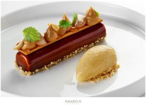 a piece of dessert on a white plate with a piece of ice cream at Queen Boutique Hotel in Krakow