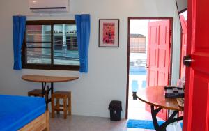 a room with a table and a red door at Tea Moon Beach House in Thong Sala