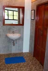a bathroom with a sink and a mirror and a door at Tea Moon Beach House in Thongsala +42 photos