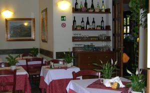 Albergo Le Rose في بستويا: مطعم به طاولتين وزجاجات من النبيذ