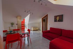 a living room with a red couch and a table at La Buhardilla de Olivia in Málaga