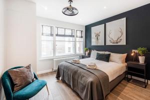 1 dormitorio con 1 cama y 1 silla azul en Be London - Chinatown Residences, en Londres