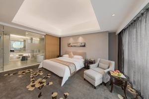 a hotel room with a bed and a chair at Huaqiang Plaza Hotel Shenzhen, Enjoy Complimentary Mini Bar & Night Snack, Add breakfast - enjoy complimentary afternoon tea in Shenzhen