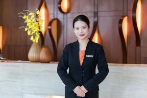 a woman standing in a room with her arms crossed at Huaqiang Plaza Hotel Shenzhen, Enjoy Complimentary Mini Bar & Night Snack, Add breakfast - enjoy complimentary afternoon tea in Shenzhen