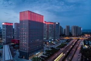 a tall building with red lights on it in a city at Mercure Xi'an Qujiang in Xi'an