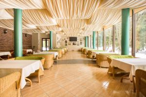 un comedor con mesas, sillas y ventanas en Arthurs Spa Hotel By Mercure, en Larevo