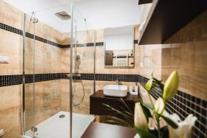 a bathroom with a glass shower and a sink at Apartmány na Bašte in Levice