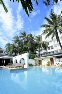 een zwembad met stoelen voor een gebouw bij Real Maris Resort and Hotel in Boracay
