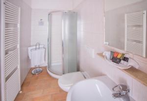uma casa de banho branca com um chuveiro e um WC. em Hotel Praga 1 em Praga